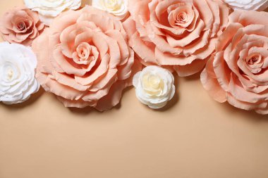 Bej arka planda güzel kağıt çiçekler, düz yatış. Metin için boşluk