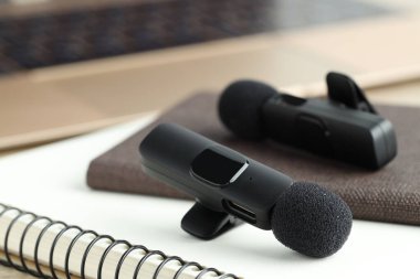 Lavalier mikrofonlar ve defterler masaya, yakın plan
