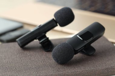 Lavalier mikrofonlar ve defter masanın üstünde, yakın plan.