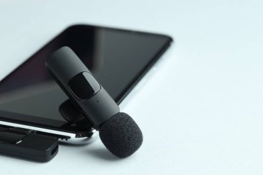 Lavalier mikrofon ve kablosuz alıcısı olan akıllı telefon, yakın plan. Metin için boşluk