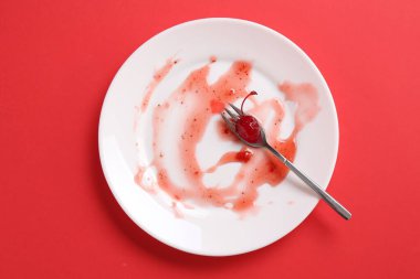 Kirli tabak ve çatal kırmızı arka plan, üst görünüm