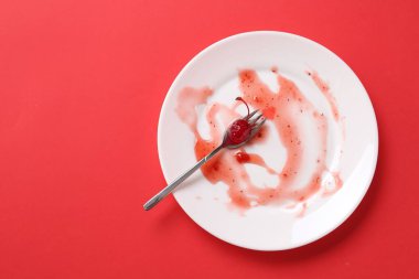 Kirli tabak ve çatal kırmızı arka planda, üst manzara. Metin için boşluk