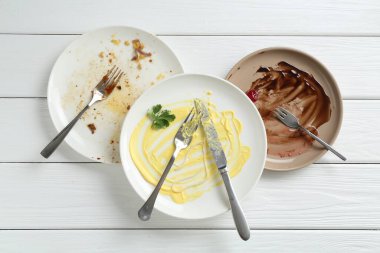 Kirli tabaklar ve çatal bıçak beyaz ahşap masa, düz yatıyordu.