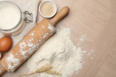 Yuvarlanan iğne, un ve yumurta tahta masada, düz yerde. Metin için boşluk