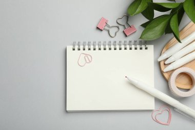 Gri arkaplanda farklı kırtasiye ve yapraklar var. Metin için boşluk