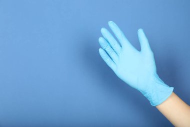 Mavi arka planda tıbbi eldiven giyen doktor, yakın plan. Metin için boşluk