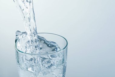 Serinletici gazoz suyunu arka plandaki bardağa boşaltıyorum. Yakın plan. Metin için boşluk