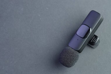 Gri arka planda Lavalier mikrofon, üst manzara. Metin için boşluk