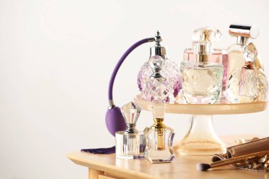 Odanın içinde ahşap tuvalet masasında farklı lüks parfümler, metin için yer.