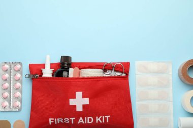 First aid kit. Different medical supplies on light blue background, flat lay. Space for text
