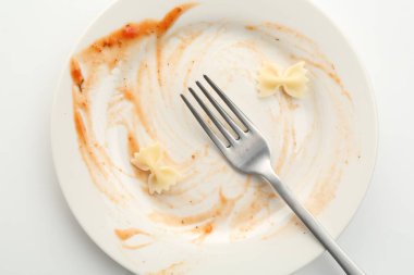 Kirli tabak ve çatal beyaz arka plan, üst görünüm