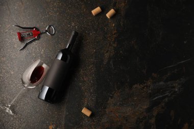 Şarap şişeleri, cam, mantar ve kanat tirbuşonu siyah masada, düz yerde. Metin için boşluk