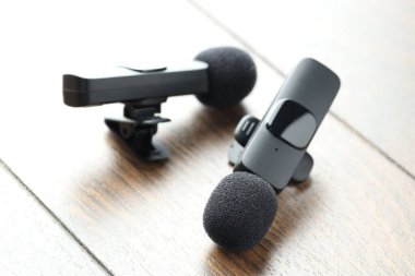 Lavalier mikrofonları ahşap masada, yakın plan. Ses ekipmanları