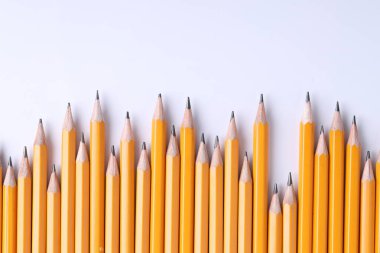 Açık gri arka planda bir sürü kalem, üst manzara. Metin için boşluk