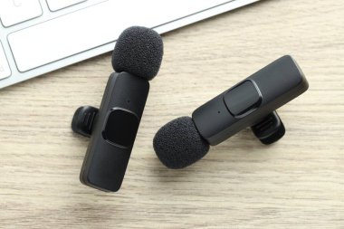 Lavalier mikrofonlar ve klavye ahşap masada, düz yatıyordu.