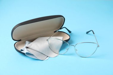 Açık mavi arka planda şık gözlüklü ve temiz giysili çanta, yakın plan