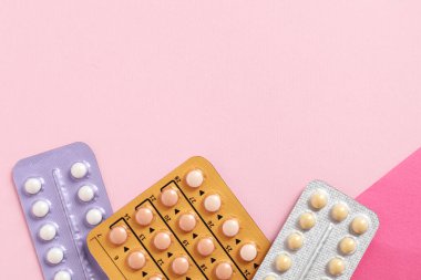 Pembe arka planda doğum kontrol hapı kabarcıkları var. Metin için boşluk