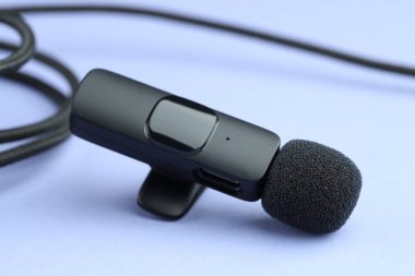 Açık mavi arkaplanda lavalier mikrofon ve kablo, yakın plan