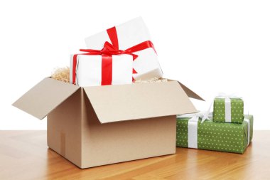 Beyaz arkaplana karşı ahşap masanın üzerinde hediye kutuları olan paket