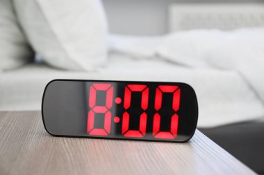 Dijital alarm saat 8 'de kapalı bir masada.