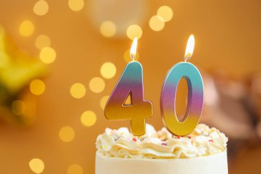 40. yaş günü. Kek üzerindeki mumların yanma sayısı bulanık arka planda ışıklar, yakın plan ve metin için boşluk. Bokeh etkisi