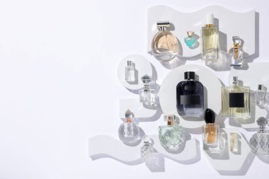 Beyaz arka planda farklı lüks parfümler, düz yatış. Metin için boşluk