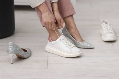 Evde ayakkabı değiştiren kadın, yakın çekim manzarası.