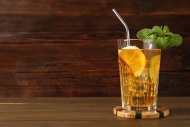 Buzlu çayı limon, limon, nane şekeri ve ahşap masada pipet içerek tazeliyorum. Metin için boşluk