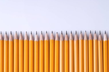 Açık gri arka planda bir sürü kalem, üst manzara. Metin için boşluk