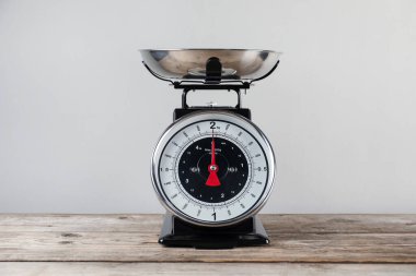 Mutfak terazisi, gri arka planda tahta tabakta.