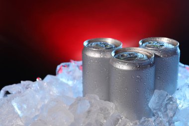 Koyu kırmızı arka planda buzlu içeceklerin tazelenmesi, yakın plan