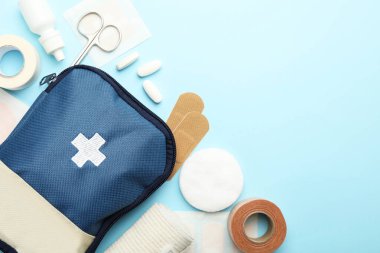 First aid kit. Different medical supplies on light blue background, flat lay. Space for text
