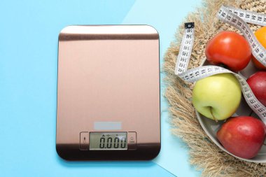 Elektronik mutfak ölçeği, mezura ve açık mavi zemin üzerindeki ürünler, düz zemin. Diyet