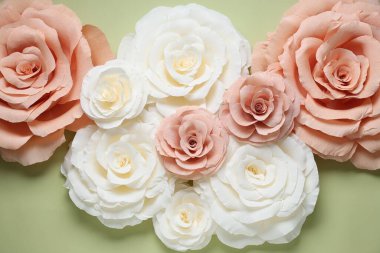 Açık yeşil zemin üzerinde güzel kağıt çiçekler, düz uzanmış