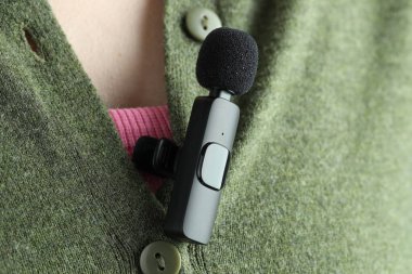 Gömleğinde lavalier mikrofon olan bir kadın, yakın plan.