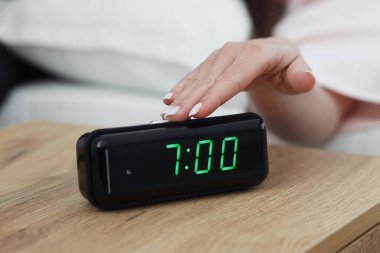 Kadın, başucundaki masanın dijital alarmını kapatıyor.