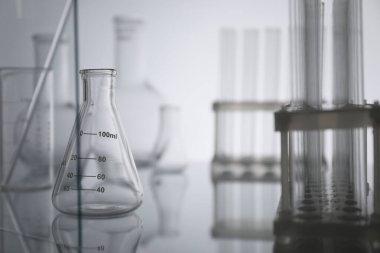 Ayna yüzeyinde ışık arkaplanına karşı laboratuvar camları