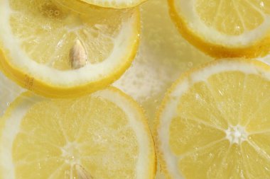 Arka planda limon dilimleri olan soda, yakın plan.