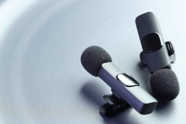Açık gri arka planda Lavalier mikrofonları, yakın plan. Metin için boşluk