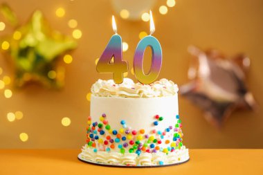 40. yaş günü. Masada yanan sayılı pasta. Arka planda bulanık ışıklar, yakın plan. Bokeh etkisi