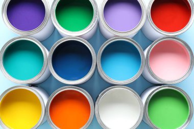 Açık mavi arkaplanda farklı boya kutuları, üst görünüm