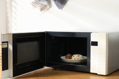 Mikrodalga fırını aç, pilav ve tavukla birlikte ahşap masa içinde.