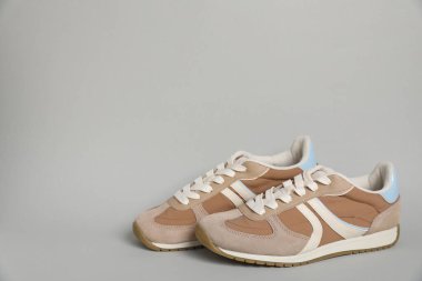 Açık gri arka planda şık bir çift spor ayakkabı, yazı için yer. Sıradan ayakkabılar.