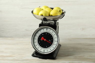 Retro mechanical kitchen scale with apples on wooden table