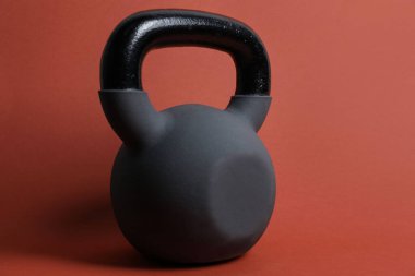 Turuncu arka planda bir tane kettlebell. Spor malzemeleri.