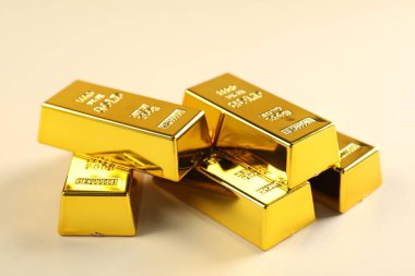 Bej arkaplanda parlak altın çubuklar, yakın plan