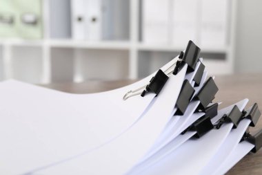 Kapalı masa üzerinde kağıt kağıtları olan ataçlar, yakın plan.