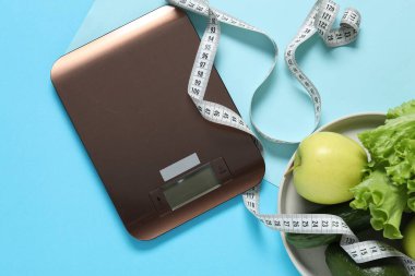 Elektronik mutfak ölçeği, mezura ve açık mavi zemin üzerindeki ürünler, düz zemin. Diyet