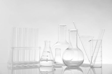 Ayna yüzeyinde ışık arkaplanına karşı laboratuvar camları