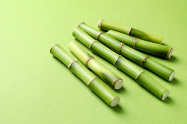 Açık yeşil arka planda bambu saplarını kes, yakın plan. Metin için boşluk